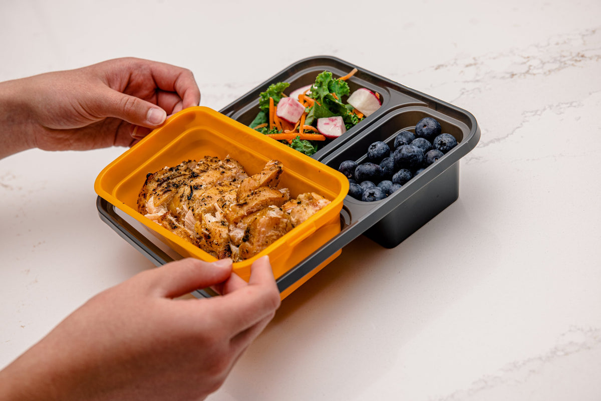 Meal Clickit container filled with chicken, salad, and blueberries